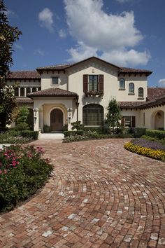 a brick driveway leading to a large house