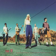 a group of young people standing on the side of a road with one woman holding a string