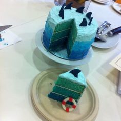 two pieces of blue cake on plates sitting on a table