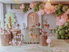 a birthday party with balloons and decorations on the wall, including deer figurines