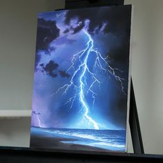 an easel with a painting of a lightning storm on it