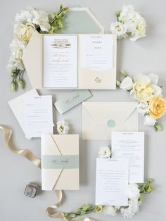 the wedding stationery is laid out on top of each other with flowers and ribbons