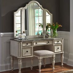 a white vanity with mirror and stool in a room