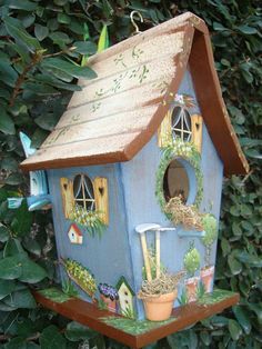 a blue birdhouse hanging from a tree