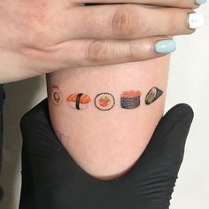 a woman's arm with sushi tattoos on it