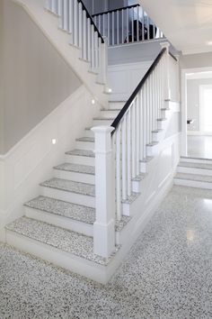 a white staircase with black handrails in a house