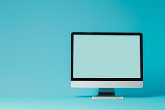 a computer monitor sitting on top of a blue table next to a keyboard and mouse