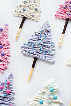 decorated cookies are arranged in the shape of christmas trees with colored icing on them