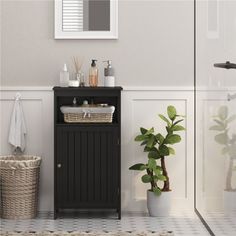 a bathroom with a black cabinet next to a plant