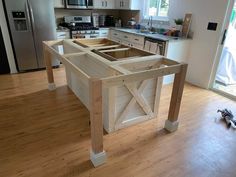 a kitchen island made out of wooden planks in the middle of a hardwood floor