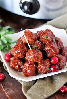 a white plate topped with meatballs and cranberries