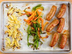 several sausages and vegetables on a baking sheet