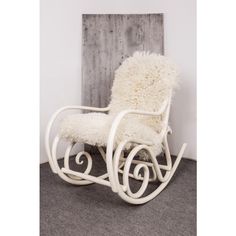 a white rocking chair sitting on top of a carpeted floor