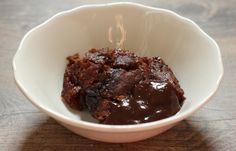 a white bowl filled with brownies on top of a wooden table