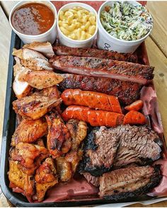 an assortment of meats and sides on a tray