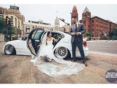 a man and woman standing next to a white car