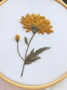 a close up of a embroidery on a piece of cloth with flowers in the middle