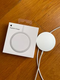 an apple charger sitting on top of a wooden table next to a white box