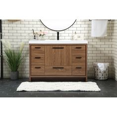 a white toilet sitting next to a wooden cabinet and sink in a room with brick walls