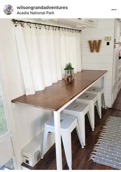 a kitchen table with stools and a potted plant sitting on top of it