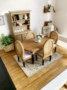 a doll house dining room with table and chairs, potted plants on top of the table