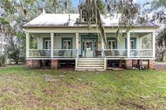 a white house with blue shutters and trees