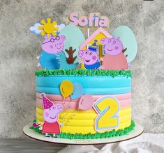 a birthday cake with peppa the pig on top is decorated in pink, blue and yellow