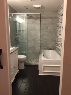 a bathroom with a walk in shower next to a toilet