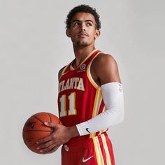 a man holding a basketball in his right hand and wearing a jersey with the number 11 on it