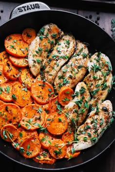 chicken and carrots in a skillet with herbs