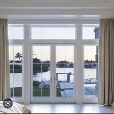 a bedroom with sliding glass doors leading to the water