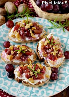 three pieces of bread topped with fruit and nuts on top of a blue and white plate