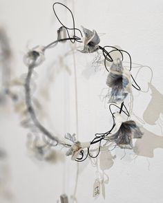 a circular piece of art hanging from the ceiling with flowers on it's sides