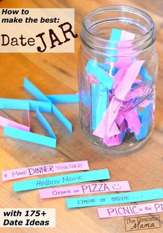 a jar filled with pink and blue paper on top of a wooden table next to other items