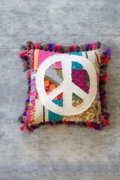 a peace sign pillow on a gray surface