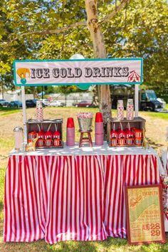 an outdoor ice cream stand with red and white striped tablecloth