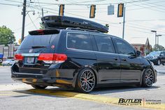 a black car is parked on the side of the road with its surfboard strapped to it's roof