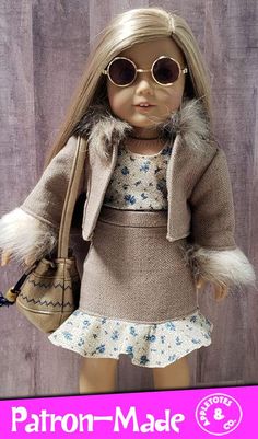 the doll is wearing a dress and jacket with fur trimmings on it's shoulders