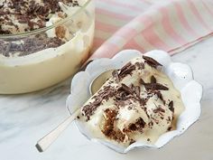 a piece of cake sitting on top of a white plate next to a glass container