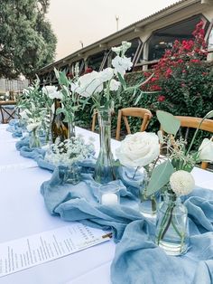 there are many vases with flowers on the table