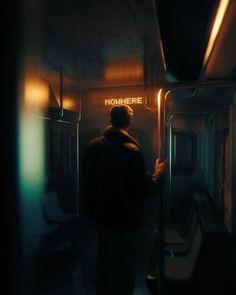 a man standing on a subway car with the lights on and no one around him