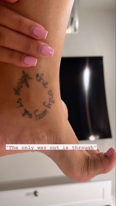 a woman's foot with writing on it that says, the only way out is through