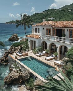 a large house with a swimming pool next to the ocean