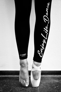 black and white photograph of woman's feet with leggings that say i love dance