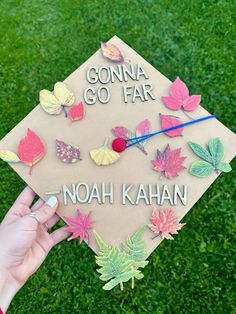 someone is holding up a graduation cap that has leaves on it and the words go far