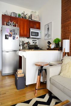 a living room with a couch and a kitchen in the backgroung area