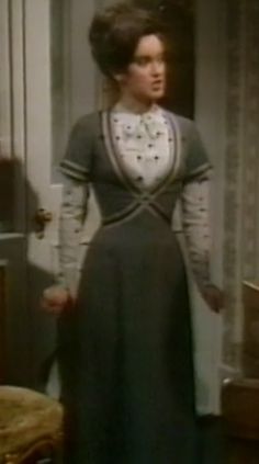 a woman standing in a room wearing a dress