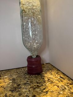 a large glass clock sitting on top of a counter next to a white wall and floor