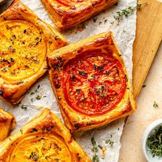 four different types of pies sitting on top of a cutting board next to some spices