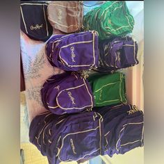 several bags are stacked on top of each other in purple and green colors, along with one another